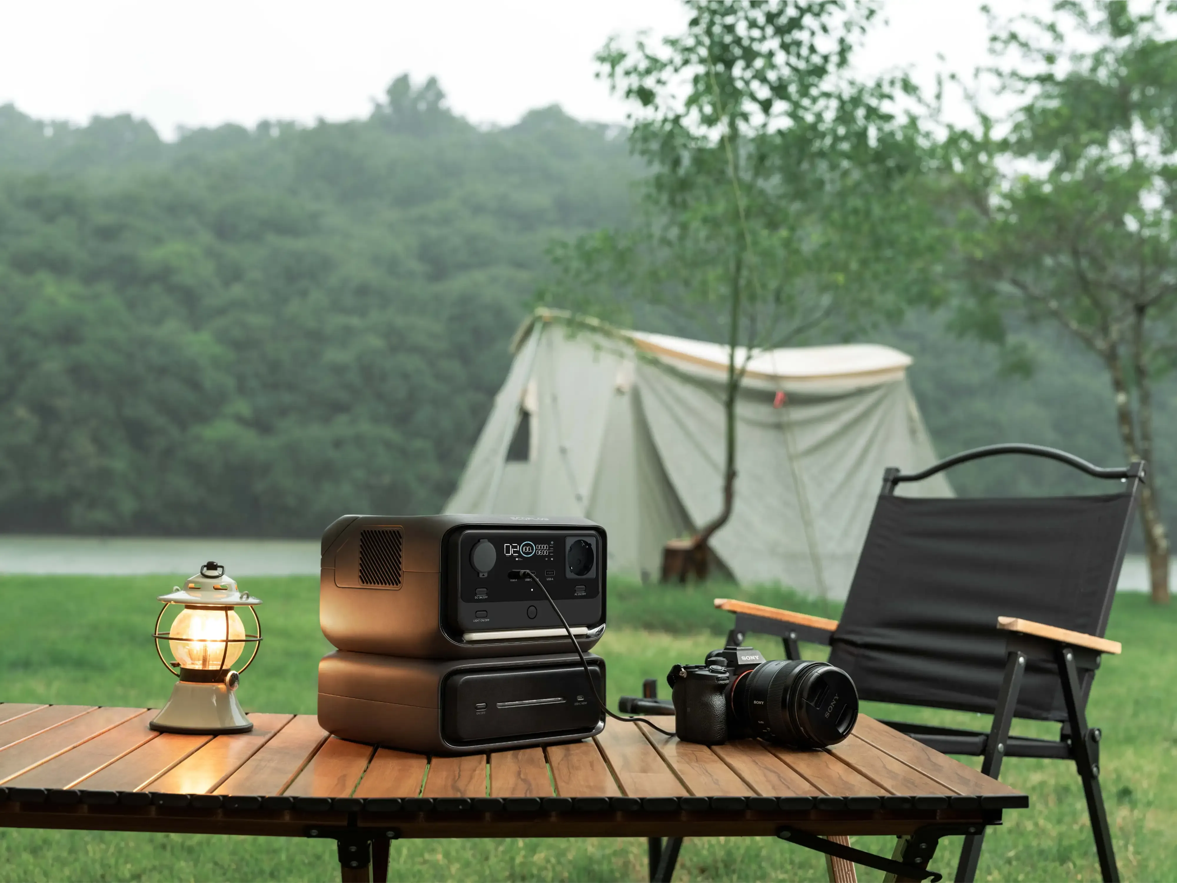 draagbaar powerstation met extra batterij op kampeertafel bij tent aan het meer