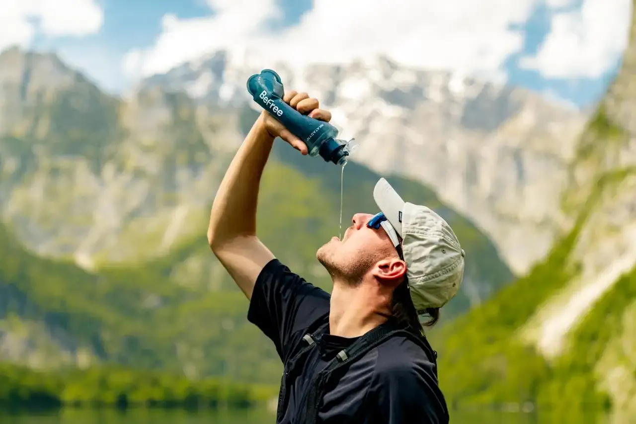 hiker drinkt gefilterd water uit katadyn befree waterfles in de bergen